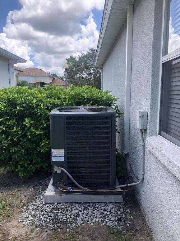Reliability meets performance with this residential AC condenser installation. Mounted on a reinforced, level pad for optimal drainage and airflow, this Goodman cooling system is built to withstand the humidity and heat of the local climate. Reliability meets performance with this residential AC condenser installation. Mounted on a reinforced, level pad for optimal drainage and airflow, this Goodman cooling system is built to withstand the humidity and heat of the local climate.